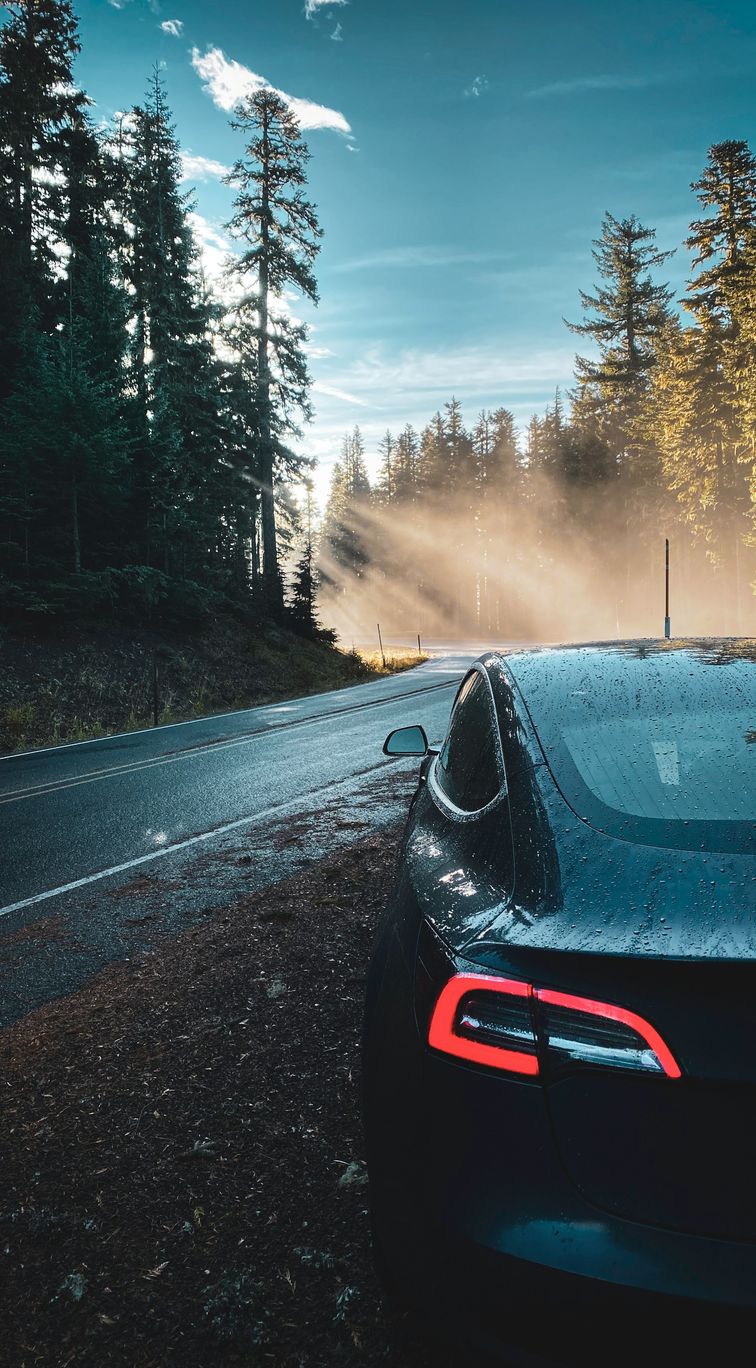 Wet tesla parked at the side of a road
